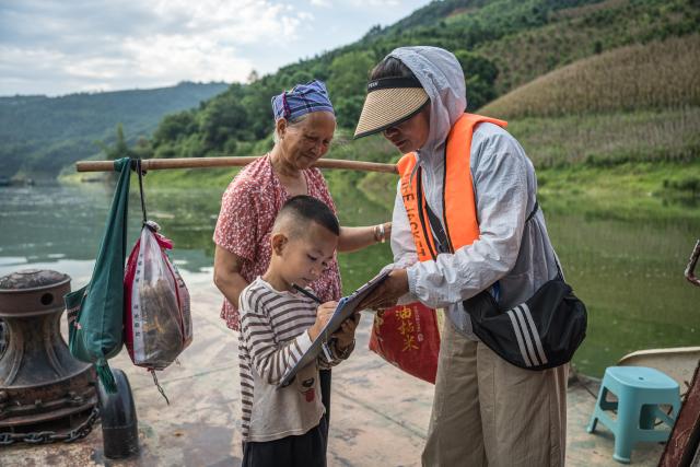 (260903) -- KUNMING, Sept. 3, 2026 (Xinhua) -- A child registers boarding information aboard a ferry in Bo'ai Town of Funing County, Wenshan Zhuang and Miao Autonomous Prefecture, southwest China's Yunnan Province, Aug. 30, 2026. (Xinhua/Wang Guansen)