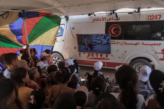 (260903) -- GAZA, Sept. 3, 2026 (Xinhua) -- Palestinian children watch cartoon on a screen mounted on a Red Crescent ambulance, dubbed the "dream bus", in the Tel al-Hawa neighborhood in Gaza City, on Sept. 2, 2026. The Dream Bus is an innovative initiative created by the Palestinian Red Crescent Association, aiming to alleviate the psychological and social pressures faced by children. (Photo by Abdul Rahman Salama/Xinhua)