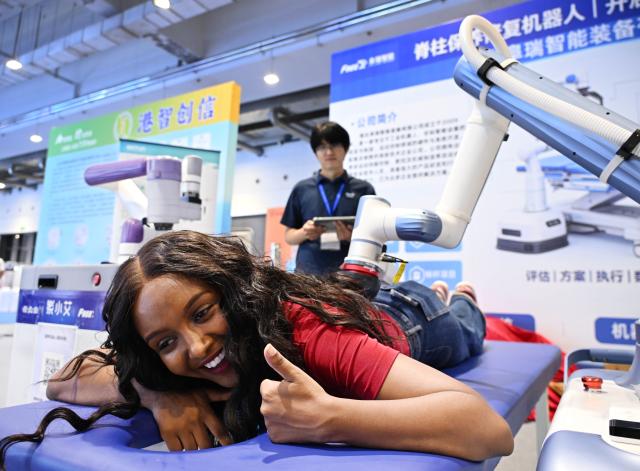 (260904) -- QINGDAO, Sept. 4, 2026 (Xinhua) -- A woman from Nigeria experiences robot massage at the 2026 China International Consumer Electronics Exposition (CICE) in Qingdao, east China's Shandong Province, Sept. 4, 2026.
  Under the theme "AI Leads the Way, Smart Technology Shapes the Future," this year's expo focuses on showcasing new products and technologies in areas such as smart homes and appliances, software technology and development, new displays, big data/cloud computing, virtual reality, and artificial intelligence. (Xinhua/Li Ziheng)