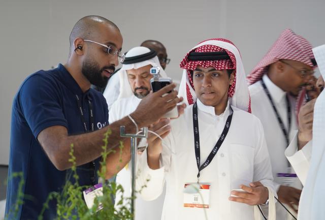 (260904) -- RIYADH, Sept. 4, 2026 (Xinhua) -- A staff member introduces the HONOR Robot Phone to a visitor at the LEAP 2026 Tech Conference in Riyadh, Saudi Arabia, Sept. 2, 2026. TO GO WITH "Feature: Chinese robots shine at LEAP 2026 in Saudi Arabia" (Xinhua/Luo Chen)