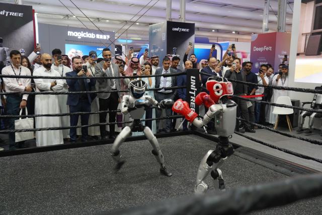 (260904) -- RIYADH, Sept. 4, 2026 (Xinhua) -- Visitors watch two humanoid robots of Unitree Robotics boxing at the LEAP 2026 Tech Conference in Riyadh, Saudi Arabia, Sept. 2, 2026. TO GO WITH "Feature: Chinese robots shine at LEAP 2026 in Saudi Arabia" (Xinhua/Luo Chen)