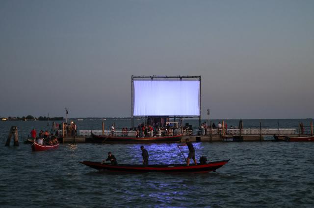 (260904) -- VENICE, Sept. 4, 2026 (Xinhua) -- People take boats to watch movie at the "Floating Cinema - Unknown Waters" event in Venice, Italy, Sept. 4, 2026. "Floating Cinema - Unknown Waters" offers a cultural event in the waters behind the island of Giudecca in the Venice Lagoon. The festival features a floating stage, viewable from private boats or a shared floating platform, where attendees can enjoy a diverse array of screenings and performances by both international and local artists. (Xinhua/Wang Kaiyan)