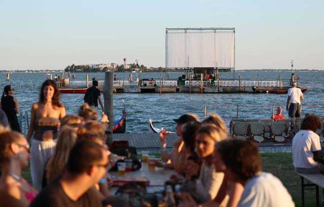 (260904) -- VENICE, Sept. 4, 2026 (Xinhua) -- People wait to watch movie at the "Floating Cinema - Unknown Waters" event while having dinner in Venice, Italy, Sept. 4, 2026. "Floating Cinema - Unknown Waters" offers a cultural event in the waters behind the island of Giudecca in the Venice Lagoon. The festival features a floating stage, viewable from private boats or a shared floating platform, where attendees can enjoy a diverse array of screenings and performances by both international and local artists. (Xinhua/Wang Kaiyan)