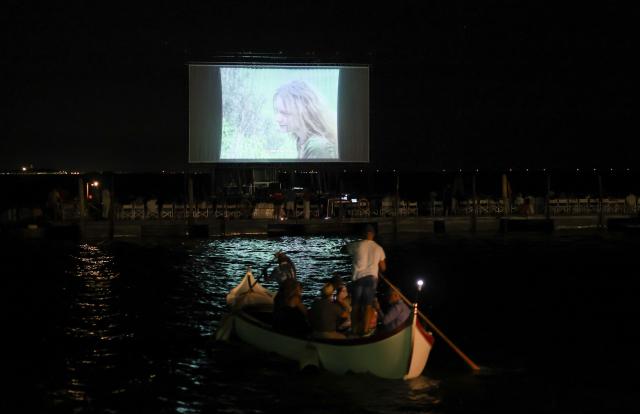 (260904) -- VENICE, Sept. 4, 2026 (Xinhua) -- People take a boat to watch movie at the "Floating Cinema - Unknown Waters" event in Venice, Italy, Sept. 4, 2026. "Floating Cinema - Unknown Waters" offers a cultural event in the waters behind the island of Giudecca in the Venice Lagoon. The festival features a floating stage, viewable from private boats or a shared floating platform, where attendees can enjoy a diverse array of screenings and performances by both international and local artists. (Xinhua/Wang Kaiyan)