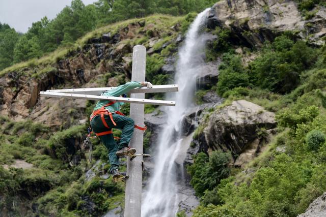 (260905) -- GYIRONG, Sept. 5, 2026 (Xinhua) -- A technician of State Grid sets up a utility pole at the core affected zone of the mudslide-hit Gyirong Port in southwest China's Xizang Autonomous Region, Sept. 2, 2026.
  TO GO WITH "Letter from Gyirong: A flag, a ruin and a promise to bring them home" (Xinhua/Zhou Yulong)