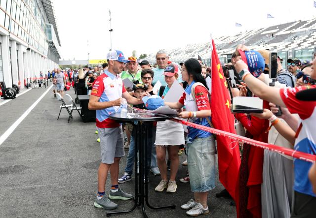 (260905) -- MAGNY-COURS, Sept. 5, 2026 (Xinhua) -- Valentin Debise (front L) of EASTROC ZXMOTO Evan Bros Factory signs for fans before the race 1 of WorldSSP at the FIM Supersport World Championship French Round in Magny-Cours, France, Sept. 5, 2026. (Xinhua/Wu Huiwo)