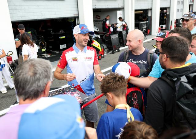 (260905) -- MAGNY-COURS, Sept. 5, 2026 (Xinhua) -- Valentin Debise (top L) of EASTROC ZXMOTO Evan Bros Factory signs for fans before the race 1 of WorldSSP at the FIM Supersport World Championship French Round in Magny-Cours, France, Sept. 5, 2026. (Xinhua/Wu Huiwo)