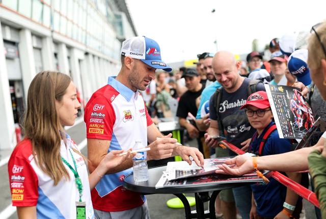 (260905) -- MAGNY-COURS, Sept. 5, 2026 (Xinhua) -- Valentin Debise (2nd L) of EASTROC ZXMOTO Evan Bros Factory signs for fans before the race 1 of WorldSSP at the FIM Supersport World Championship French Round in Magny-Cours, France, Sept. 5, 2026. (Xinhua/Wu Huiwo)