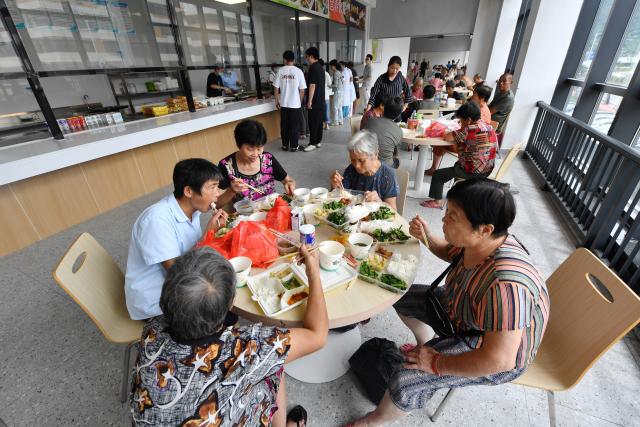 (260905) -- PUTIAN, Sept. 5, 2026 (Xinhua) -- Relocated residents have lunch at a resettlement site in Putian City, southeast China's Fujian Province, Sept. 5, 2026. As this round of heavy rainfall in Putian concluded on Saturday, floodwaters gradually receded in areas including Huating Town, which had been severely inundated by Typhoon Saudel. Local authorities have since shifted to post-disaster recovery, undertaking tasks including road clearance, water and power restoration, environmental dredging, and the resettlement of affected residents. (Xinhua/Jiang Kehong)