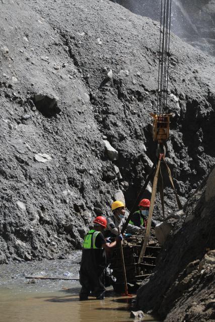 (260905) -- GYIRONG, Sept. 5, 2026 (Xinhua) -- Workers load stones for road-reinforcement at the core affected zone of the mudslide-hit Gyirong Port in southwest China's Xizang Autonomous Region, Sept. 5, 2026. More rescue forces have entered the core affected zone of the mudslide-hit Gyirong Port on Saturday. China Railway Group Limited have provided steel gabions to the site for road-reinforcement. (Photo by Chen Xiaojun/Xinhua)