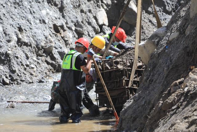 (260905) -- GYIRONG, Sept. 5, 2026 (Xinhua) -- Workers load stones for road-reinforcement at the core affected zone of the mudslide-hit Gyirong Port in southwest China's Xizang Autonomous Region, Sept. 5, 2026. More rescue forces have entered the core affected zone of the mudslide-hit Gyirong Port on Saturday. China Railway Group Limited have provided steel gabions to the site for road-reinforcement. (Photo by Chen Xiaojun/Xinhua)