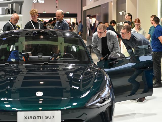 (260905) -- BERLIN, Sept. 5, 2026 (Xinhua) -- People view a Xiaomi SU7 at the exhibition area of Xiaomi at IFA Berlin 2026 in Berlin, Germany, Sept. 5, 2026.
  IFA Berlin 2026, one of the world's largest trade fairs for consumer electronics and home appliances, opened Friday, with robotics and artificial intelligence (AI) taking center stage.
   At this year's IFA, Chinese brands continue to maintain a strong presence. Companies including TCL, Hisense, Haier, DJI and Xiaomi showcased their latest products and technologies, attracting considerable attention from media and visitors. (Xinhua/Zhang Haofu)