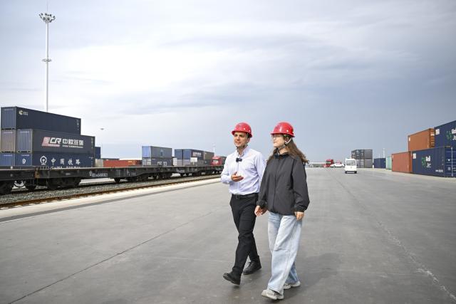 (260906) -- URUMQI, Sept. 6, 2026 (Xinhua) -- Arseniy Kretov (L) and his Chinese partner walk at the Urumqi cargo terminal of China United International Rail Containers Co., Ltd. (CRIntermodal) in Urumqi, northwest China's Xinjiang Uygur Autonomous Region, Sept. 2, 2026.
  Arseniy Kretov, 27, who goes by the Chinese name Yu Hao, hails from Tashkent, Uzbekistan. He is the regional representative of O'ZTEMIRYO'LKONTEYNER (UTK) in China and mainly works in cross-border logistics. 
  Interested in China, Arseniy went to Nanjing in Jiangsu Province to study. During his three years there, he was deeply impressed by China's transportation, medical services and food. After starting his career, UTK dispatched Arseniy to Xinjiang because he was fluent in Chinese. 
  Arseniy currently works with a Chinese team in Urumqi. His company transports consumer goods, electronic products, fabrics and other products made in China to countries in Central Asia and elsewhere. 
  Although Arseniy has worked in Xinjiang for less than a year, he has already found many market opportunities. His team's business volume has increased every month, which has given him more confidence. Arseniy said logistics between China and Central Asia is more than just a job for him. It is a field with promising prospects. (Xinhua/Hu Huhu)