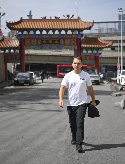 (260906) -- URUMQI, Sept. 6, 2026 (Xinhua) -- Arseniy Kretov walks to work in Urumqi, northwest China's Xinjiang Uygur Autonomous Region, Sept. 3, 2026.
  Arseniy Kretov, 27, who goes by the Chinese name Yu Hao, hails from Tashkent, Uzbekistan. He is the regional representative of O'ZTEMIRYO'LKONTEYNER (UTK) in China and mainly works in cross-border logistics. 
  Interested in China, Arseniy went to Nanjing in Jiangsu Province to study. During his three years there, he was deeply impressed by China's transportation, medical services and food. After starting his career, UTK dispatched Arseniy to Xinjiang because he was fluent in Chinese. 
  Arseniy currently works with a Chinese team in Urumqi. His company transports consumer goods, electronic products, fabrics and other products made in China to countries in Central Asia and elsewhere. 
  Although Arseniy has worked in Xinjiang for less than a year, he has already found many market opportunities. His team's business volume has increased every month, which has given him more confidence. Arseniy said logistics between China and Central Asia is more than just a job for him. It is a field with promising prospects. (Xinhua/Hu Huhu)