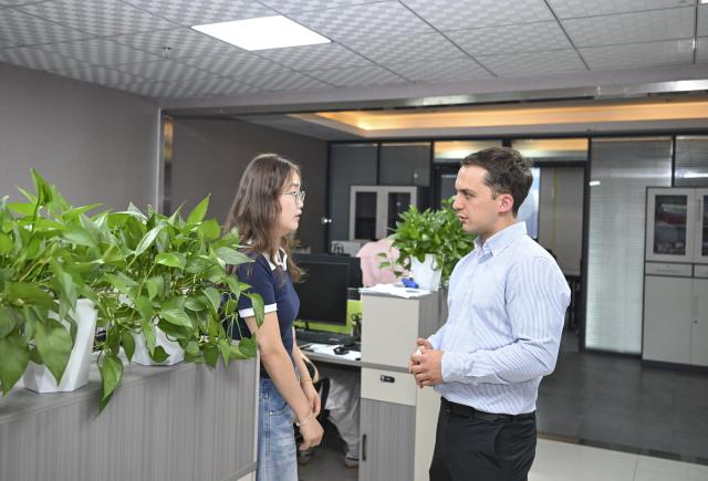 (260906) -- URUMQI, Sept. 6, 2026 (Xinhua) -- Arseniy Kretov (R) talks with his Chinese partner at an office in Urumqi, northwest China's Xinjiang Uygur Autonomous Region, Sept. 2, 2026.
  Arseniy Kretov, 27, who goes by the Chinese name Yu Hao, hails from Tashkent, Uzbekistan. He is the regional representative of O'ZTEMIRYO'LKONTEYNER (UTK) in China and mainly works in cross-border logistics. 
  Interested in China, Arseniy went to Nanjing in Jiangsu Province to study. During his three years there, he was deeply impressed by China's transportation, medical services and food. After starting his career, UTK dispatched Arseniy to Xinjiang because he was fluent in Chinese. 
  Arseniy currently works with a Chinese team in Urumqi. His company transports consumer goods, electronic products, fabrics and other products made in China to countries in Central Asia and elsewhere. 
  Although Arseniy has worked in Xinjiang for less than a year, he has already found many market opportunities. His team's business volume has increased every month, which has given him more confidence. Arseniy said logistics between China and Central Asia is more than just a job for him. It is a field with promising prospects. (Xinhua/Hu Huhu)