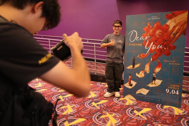 (260906) -- BEIJING, Sept. 6, 2026 (Xinhua) -- A moviegoer poses for a photo with a poster of Chinese box-office hit "Dear You" at a cinema in Los Angeles County, California, the United States, Sept. 3, 2026. (Photo by Zeng Hui/Xinhua)