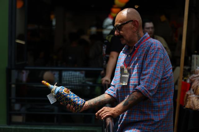 (260906) -- MEXICO CITY, Sept. 6, 2026 (Xinhua) -- An exhibitor displays a bottle of mezcal, an alcoholic beverage made from the agave plant, decorated with traditional handwoven fabric during the Pulque, Traditional Cuisine and Mezcal Festival in Mexico City, capital of Mexico, Sept. 5, 2026. The event, featuring more than 100 varieties and expressions of agave-based beverages, as well as tastings, food pairings and other activities, was held in Mexico City on Saturday. (Photo by Francisco Canedo/Xinhua)
