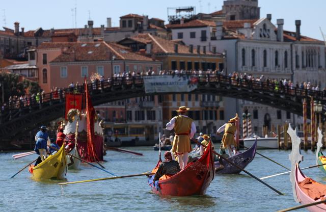 (260906) -- VENICE, Sept. 6, 2026 (Xinhua) -- People sail past the Accademia Bridge in the Regata Storica boat race in Venice, Italy, Sept. 6, 2026. The Regata Storica is a historic annual boat parade and rowing race on the Grand Canal in Venice. (Xinhua/Wang Kaiyan)