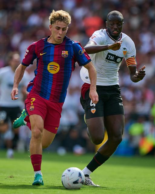 (260907) -- VALENCIA, Sept. 7, 2026 (Xinhua) -- Barcelona's Fermin Lopez (L) vies with Valencia's Mouctar Diakhaby during the Spanish La Liga football match between Valencia CF and FC Barcelona in Valencia, Spain, Sept. 6, 2026. (Str/Xinhua)