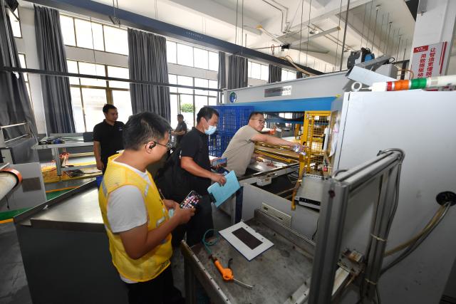 (260907) -- PUTIAN, Sept. 7, 2026 (Xinhua) -- Staff members check the condition of a shoemaking machine at a factory at the Hualin economic development zone in Putian, southeast China's Fujian Province, Sept. 7, 2026. As heavy rainfall caused by Typhoon Saudel in Putian concluded on Saturday, floodwaters gradually receded in inundated areas of this city. Local authorities have since shifted to post-disaster recovery, undertaking tasks including water and power restoration, sanitation and disinfection, as well as the resettlement of affected residents. (Xinhua/Jiang Kehong)