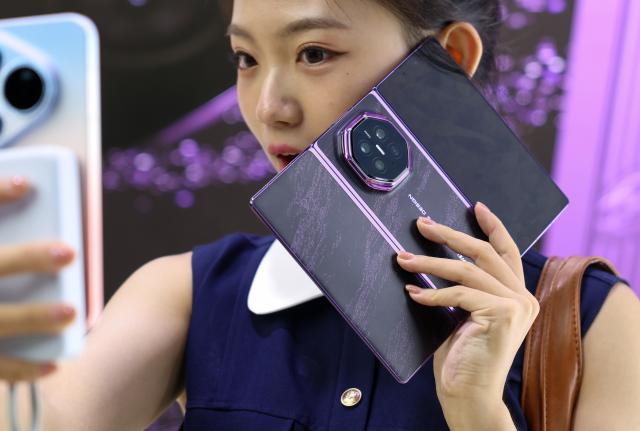 (260907) -- GUANGZHOU, Sept. 7, 2026 (Xinhua) -- An audience member takes a selfie with Huawei's Mate XT 2 tri-fold smartphone powered by the new Kirin 9050 Pro chip after a launch event in Guangzhou, south China's Guangdong Province, Sept. 7, 2026. Chinese tech giant Huawei on Monday launched the Mate XT 2 tri-fold smartphone powered by the new Kirin 9050 Pro chip, the first high-performance processor to use logic folding technology.
  The Kirin 9050 Pro stacks logic units in layers within a single chip, shortening signal transmission paths, reducing latency and boosting overall performance, according to a launch event in Guangzhou.
  The last time Huawei introduced a new Kirin chip at a flagship launch was at the global release of the Mate 40 smartphone six years ago. The company has continued to innovate and break new ground in recent years. (Xinhua/Mao Siqian)