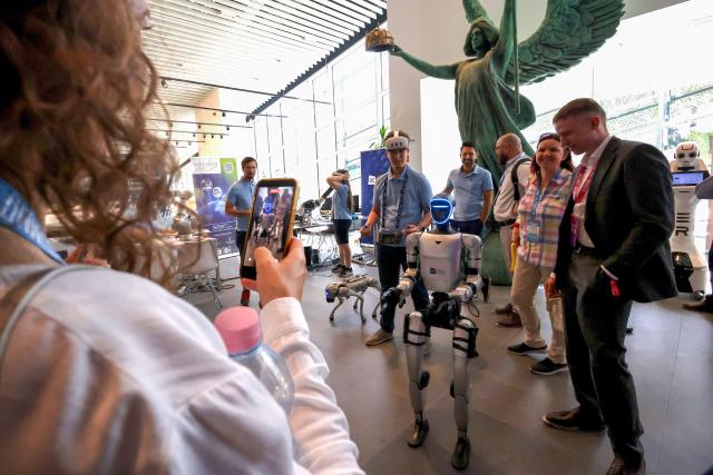(260907) -- BUDAPEST, Sept. 7, 2026 (Xinhua) -- People look at a humanoid robot at the AI Summit Budapest 2026 in Budapest, Hungary on Sept. 7, 2026. (Photo by Attila Volgyi/Xinhua)