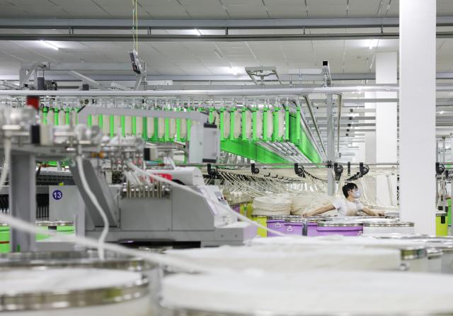 (260908) -- YUDU, Sept. 8, 2026 (Xinhua) -- A worker works on a cotton yarn production line at a textile company in Yudu County, east China's Jiangxi Province, Sept. 3, 2026. Yudu, one of the starting points of the Central Red Army's Long March, the epic 1934-1936 trek that broke through Kuomintang siege, has in recent years  focused on developing the textile and garment industry, forming a complete industrial chain from spinning, weaving, printing, garment manufacturing and e-commerce sales. The revenue of the industry here exceeded 100 billion yuan (about 14.9 billion U.S. dollars) in 2025, creating nearly 200,000 jobs. (Xinhua/Wang Jingqiang)