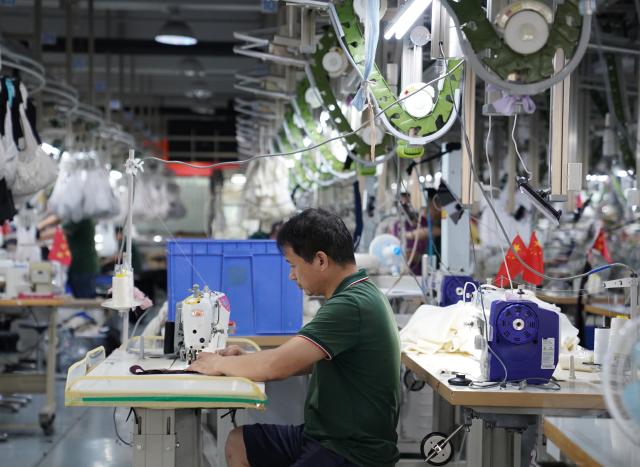 (260908) -- YUDU, Sept. 8, 2026 (Xinhua) -- A worker works on a production line of a fashion company in Yudu County, east China's Jiangxi Province, Sept. 3, 2026. Yudu, one of the starting points of the Central Red Army's Long March, the epic 1934-1936 trek that broke through Kuomintang siege, has in recent years  focused on developing the textile and garment industry, forming a complete industrial chain from spinning, weaving, printing, garment manufacturing and e-commerce sales. The revenue of the industry here exceeded 100 billion yuan (about 14.9 billion U.S. dollars) in 2025, creating nearly 200,000 jobs. (Xinhua/Zhou Mi)