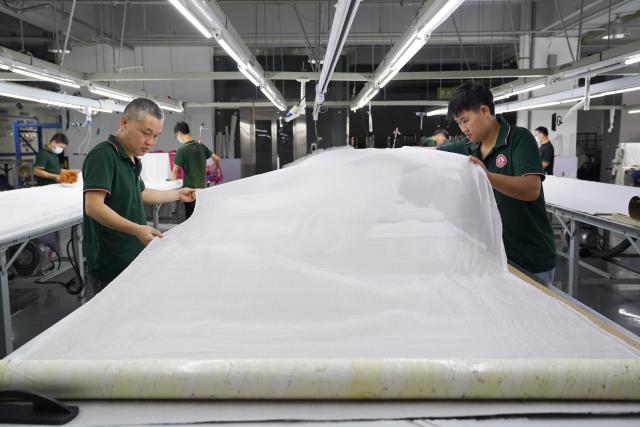 (260908) -- YUDU, Sept. 8, 2026 (Xinhua) -- Workers work at a workshop of a fashion company in Yudu County, east China's Jiangxi Province, Sept. 3, 2026. Yudu, one of the starting points of the Central Red Army's Long March, the epic 1934-1936 trek that broke through Kuomintang siege, has in recent years  focused on developing the textile and garment industry, forming a complete industrial chain from spinning, weaving, printing, garment manufacturing and e-commerce sales. The revenue of the industry here exceeded 100 billion yuan (about 14.9 billion U.S. dollars) in 2025, creating nearly 200,000 jobs. (Xinhua/Zhou Mi)