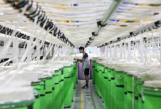 (260908) -- YUDU, Sept. 8, 2026 (Xinhua) -- A worker works on a cotton yarn production line at a textile company in Yudu County, east China's Jiangxi Province, Sept. 3, 2026. Yudu, one of the starting points of the Central Red Army's Long March, the epic 1934-1936 trek that broke through Kuomintang siege, has in recent years  focused on developing the textile and garment industry, forming a complete industrial chain from spinning, weaving, printing, garment manufacturing and e-commerce sales. The revenue of the industry here exceeded 100 billion yuan (about 14.9 billion U.S. dollars) in 2025, creating nearly 200,000 jobs. (Xinhua/Wang Jingqiang)