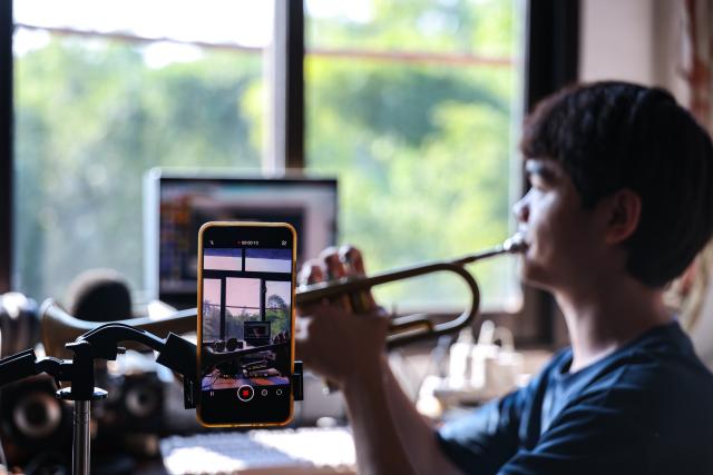 (260908) -- BEIJING, Sept. 8, 2026 (Xinhua) -- Wang Taifan records a video of him playing a trumpet at home in Shuangsheng Village of Tongliang District, southwest China's Chongqing Municipality, Sept. 5, 2026. Wang Taifan, who took part in the performance of the Paralympic Anthem at the opening ceremony of the Beijing 2022 Paralympic Winter Games, recently began his college life as a musicology freshman at the Special Education College of Beijing Union University. 
  Born in Tongliang District of southwest China's Chongqing, Wang lost his sight at the age of 12 due to an eye disease. After enrolled in the Chongqing Special Education Center, he learned to play the trumpet with the help of his teachers and joined a wind ensemble composed of vision limited individuals. The trumpet enabled Wang to experience a wider world as he traveled to many cities and stepped onto bigger stages with his bandmates. As a new chapter of his life begins, Wang looks forward to a solo concert of his own. (Xinhua/Huang Wei)