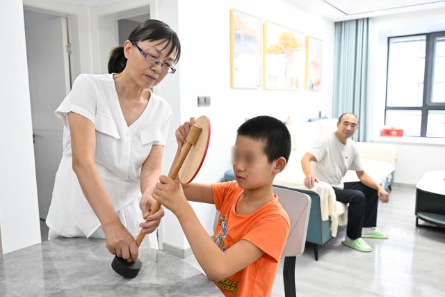 (260908) -- JINHU, Sept. 8, 2026 (Xinhua) -- Hu Xuemei, a teacher of Jinhu Special Education School, teaches a student about traffic rules in Jinhu County of Huai'an, east China's Jiangsu Province, Sept. 8, 2026.
  In 2016, Jinhu Special Education School launched a home-based teaching program for children with severe disabilities. Over the past decade, teachers involved in the program have traveled nearly 80,000 kilometers across the county to teach students in their homes.
  For each child, the teachers develop an individualized education plan covering cognitive development, daily living skills and rehabilitation training, while also providing families with parenting and caregiving guidance. Through patience and consistent efforts, they have gradually earned the children's trust and helped many of them make notable progress.
  Over the past 10 years, eight children have successfully made the transition from home-based education to attending school. A total of 42 children with severe disabilities have received systematic education and rehabilitation services. (Xinhua/Ji Chunpeng)