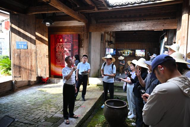 (260908) -- NINGHUA, Sept. 8, 2026 (Xinhua) -- An offspring of the Red Army (1st L) introduces revolutionary history in Xiacao Village in Ninghua County, southeast China's Fujian Province, Sept. 8, 2026. This year marks the 90th anniversary of the victory of the Long March by the Red Army under the leadership of the Communist Party of China (CPC). Ninghua is one of the starting points of the Long March by the Central Red Army. Xiacao Village in Ninghua has profound heritage of revolutionary history. (Xinhua/Zheng Huansong)