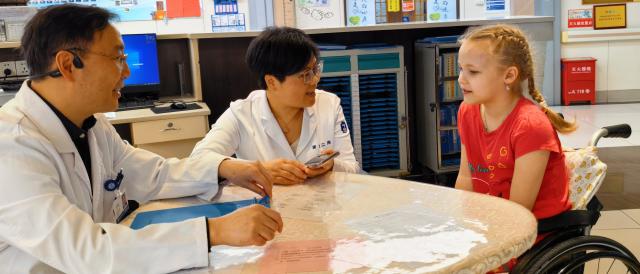 (260909) -- BEIJING, Sept. 9, 2026 (Xinhua) -- Doctors communicate with Russian girl Vera, a pseudonym, at the Second Affiliated Hospital, Zhejiang University School of Medicine in Hangzhou, east China's Zhejiang Province, April 17, 2026.
  TO GO WITH "China Focus: From spinal implant to cancer therapy, foreign patients seek out China's medical advances" (Xinhua)