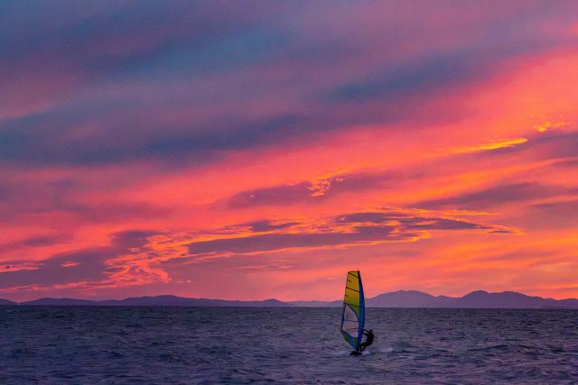 (260909) -- VLADIVOSTOK, Sept. 9, 2026 (Xinhua) -- A water sports enthusiast windsurfs in the Russian Far East city of Vladivostok, Sept. 8, 2026. A water sports festival was held here on Tuesday, attracting dozens of enthusiasts. (Photo by Andrey Matveenko/Xinhua)