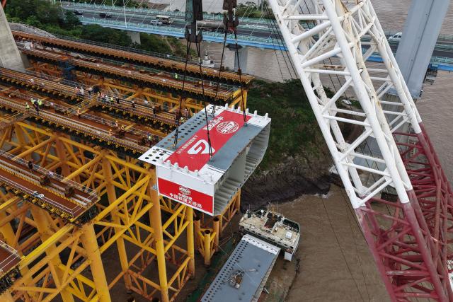 (260909) -- ZHOUSHAN, Sept. 9, 2026 (Xinhua) -- An aerial drone photo taken on Sept. 8, 2026 shows the first steel box girder of the Taoyaomen highway-railway bridge being set in Zhoushan, east China's Zhejiang Province. The first steel box girder of Taoyaomen highway-railway bridge, constructed by the China Railway Major Bridge Engineering Group Co., Ltd., was successfully set on Tuesday, marking a significant breakthrough of this project. (Xinhua/Huang Zongzhi)