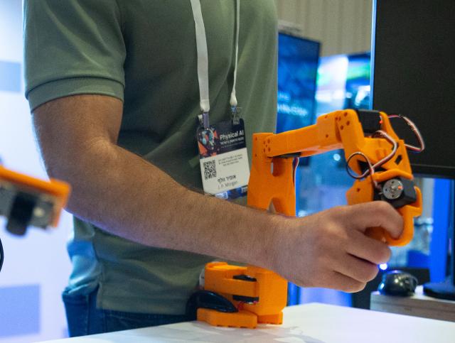 (260909) -- TEL AVIV, Sept. 9, 2026 (Xinhua) -- A visitor experiences an AI-powered robotic hand at Israel's First National Physical AI Conference in Tel Aviv, Israel, Sept. 8, 2026. Israel's first National Physical AI Conference, hosted by Israel's National AI Directorate, was held here on Tuesday, showcasing physical AI applications across industry, medicine, entertainment, infrastructure, and defense under the theme "Artificial Intelligence Moving from the Screen to the Physical World." (Xinhua/Chen Junqing)