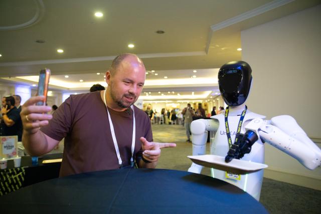 (260909) -- TEL AVIV, Sept. 9, 2026 (Xinhua) -- A man interacts with an AI robot from China at Israel's First National Physical AI Conference in Tel Aviv, Israel, Sept. 8, 2026. Israel's first National Physical AI Conference, hosted by Israel's National AI Directorate, was held here on Tuesday, showcasing physical AI applications across industry, medicine, entertainment, infrastructure, and defense under the theme "Artificial Intelligence Moving from the Screen to the Physical World." (Xinhua/Chen Junqing)