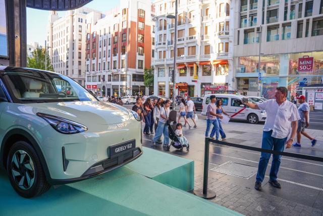 (260909) -- MADRID, Sept. 9, 2026 (Xinhua) -- A man takes photos of a Geely E2 electric vehicle on Gran Via in Madrid, Spain, on Sept. 9, 2026. Chinese automaker Geely Auto launched its new electric vehicle, the Geely E2, in Madrid on Wednesday, marking the introduction of its third model in Spain less than six months after it entered the Spanish market. (Photo by Zhang Yuheng/Xinhua)