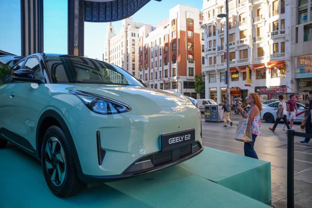 (260909) -- MADRID, Sept. 9, 2026 (Xinhua) -- A woman takes photos of a Geely E2 electric vehicle on Gran Via in Madrid, Spain, on Sept. 9, 2026. Chinese automaker Geely Auto launched its new electric vehicle, the Geely E2, in Madrid on Wednesday, marking the introduction of its third model in Spain less than six months after it entered the Spanish market. (Photo by Zhang Yuheng/Xinhua)