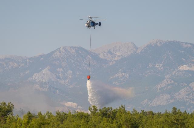 (260909) -- ANTALYA, Sept. 9, 2026 (Xinhua) -- A helicopter tries to extinguish wildfire in the Aksu district of Antalya, Türkiye, Sept. 9, 2026. One person died Wednesday after suffering a heart attack amid a wildfire in Türkiye's southern province of Antalya, as firefighters continued efforts to bring the blaze under control, local authorities and media reported. (Mustafa Kaya/Handout via Xinhua)