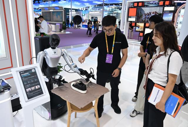(260910) -- XIAMEN, Sept. 10, 2026 (Xinhua) -- Visitors watch a robot demonstrating how to tie shoelace at the 26th China International Fair for Investment and Trade in Xiamen, southeast China's Fujian Province, Sept. 9, 2026. The 26th China International Fair for Investment and Trade opened Tuesday in Xiamen, drawing registrations from more than 1,200 government institutions and business delegations from 129 countries and regions, as well as 30 international organizations. Technological achievements in cutting-edge fields including artificial intelligence, low-altitude economy, new energy storage, and green power are showcased in this event. (Xinhua/Lin Shanchuan)
