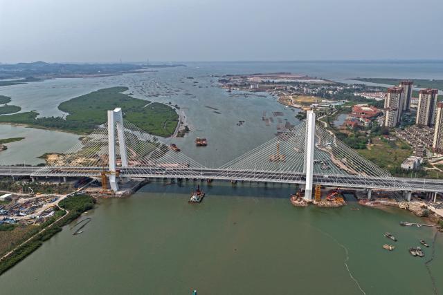 (260910) -- NANNING, Sept. 10, 2026 (Xinhua) -- An aerial drone photo taken on March 31, 2026 shows a bridge near the estuary of the Pinglu Canal in Qinzhou City, south China's Guangxi Zhuang Autonomous Region. Pinglu Canal in south China's Guangxi Zhuang Autonomous Region will become operational on Sept. 16. The 134.2-km canal links the Xijiang River shipping route in the north with the Beibu Gulf in the south. It is China's first major river-to-sea canal project that has been planned and coordinated at the national level since 1949.
   Centering the Pinglu Canal Economic Belt as its main artery, Guangxi focuses on large-capacity, port and waterway-related industries. It builds port-adjacent parks along the canal tailored to local conditions, forming industrial clusters that support upstream and downstream industries and foster collaboration among large, medium, and small enterprises.
   Across Guangxi, localities leverage their own resources to position themselves within a maritime-oriented industrial layout, advancing the high-quality development of the marine economy. (Xinhua/Zhou Hua)