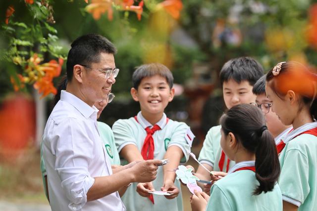 (260910) -- BEIJING, Sept. 10, 2026 (Xinhua) -- Students give greeting cards to their teacher at a primary school in Jiaxing, east China's Zhejiang Province, Sept. 10, 2026. China marked its 42nd Teachers' Day on Thursday with various activities held to express gratitude to teachers across the country. (Photo by Jin Peng/Xinhua)