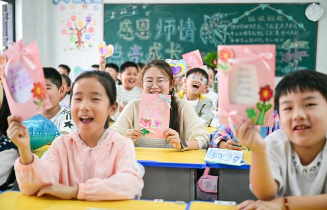(260910) -- BEIJING, Sept. 10, 2026 (Xinhua) -- Students pose for a group photo with a teacher at a primary school in Shangqiu, central China's Henan Province, Sept. 10, 2026. China marked its 42nd Teachers' Day on Thursday with various activities held to express gratitude to teachers across the country. (Photo by Wang Gaochao/Xinhua)