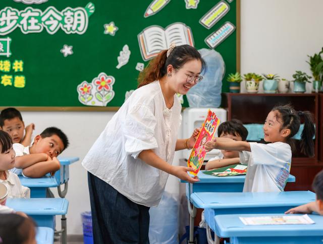 (260910) -- BEIJING, Sept. 10, 2026 (Xinhua) -- A student gives a greeting card to her teacher at a primary school in Yangzhou, east China's Jiangsu Province, Sept. 10, 2026. China marked its 42nd Teachers' Day on Thursday with various activities held to express gratitude to teachers across the country. (Photo by Ren Fei/Xinhua)
