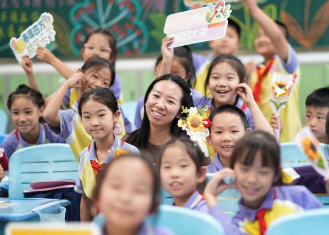 (260910) -- BEIJING, Sept. 10, 2026 (Xinhua) -- Students pose for a group photo with a teacher at a primary school in north China's Tianjin, Sept. 10, 2026. China marked its 42nd Teachers' Day on Thursday with various activities held to express gratitude to teachers across the country. (Photo by Du Penghui/Xinhua)