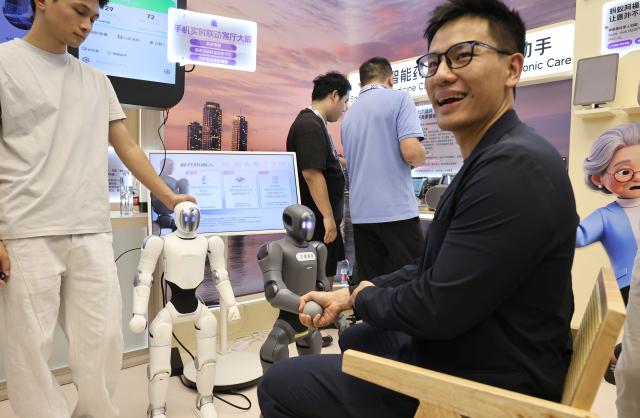 (260910) -- SHANGHAI, Sept. 10, 2026 (Xinhua) -- A visitor measures his blood oxygen levels and heart rate through a handshake with a robot during the 2026 Inclusion Conference on the Bund in Shanghai, east China, Sept. 10, 2026. Under the theme of "Building the AI Economy Together," the 2026 edition of the conference is held here from Wednesday to Saturday. It features a main forum and more than 40 sub-forums. A technology exhibition covering nearly 15,000 square meters is also staged during the conference, attracting over 300 sci-tech exhibitors. (Xinhua/Fang Zhe)
