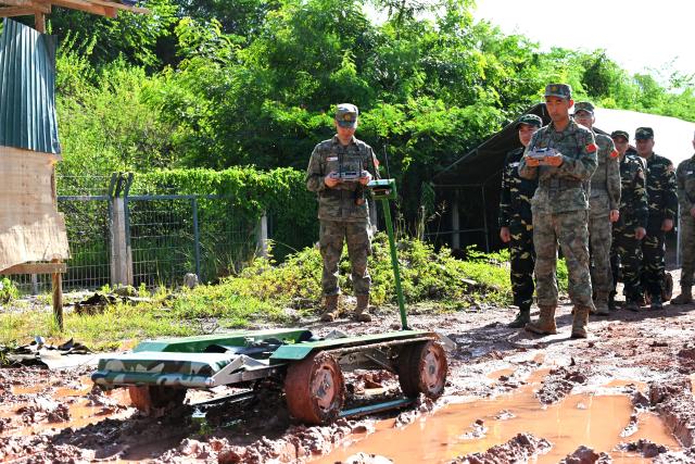 (260910) -- VIENTIANE, Sept. 10, 2026 (Xinhua) -- Participating team members deploy unmanned intelligent equipment during a mixed-unit joint training phase of the China-Laos "Peace Train-2026" joint humanitarian medical rescue exercise in Vientiane, Laos, Sept. 9, 2026. TO GO WITH "China, Laos use drones, robot dogs in 'Peace Train-2026' medical exercise" (Photo by Zeng Li/Xinhua)