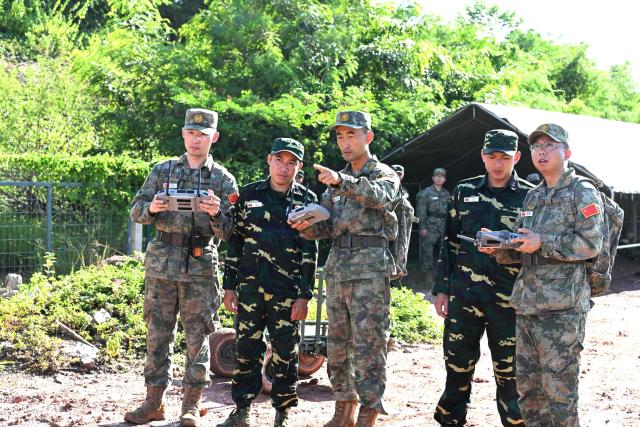 (260910) -- VIENTIANE, Sept. 10, 2026 (Xinhua) -- Chinese participating team members instruct their Lao counterparts on how to use unmanned equipment during the mixed-unit joint training phase of the China-Laos "Peace Train-2026" joint humanitarian medical rescue exercise in Vientiane, Laos, Sept. 9, 2026. TO GO WITH "China, Laos use drones, robot dogs in 'Peace Train-2026' medical exercise" (Photo by Zeng Li/Xinhua)